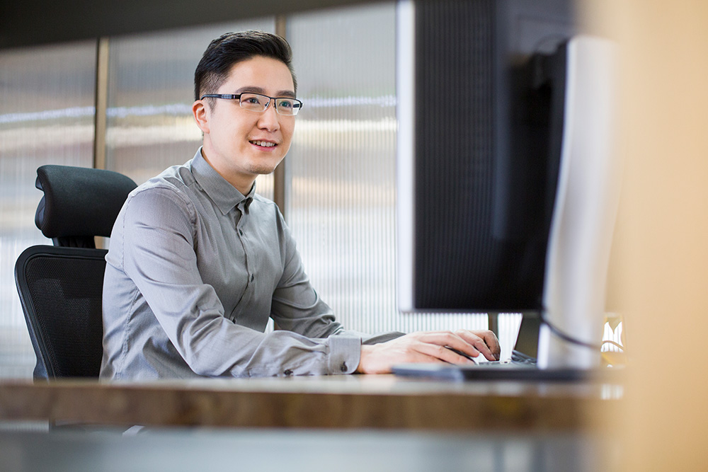 Office worker in New Zealand smiling while working