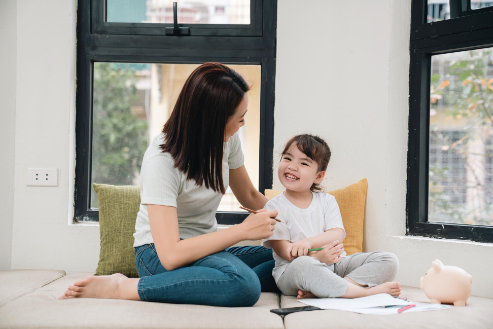University Student tutoring young kid while smiling